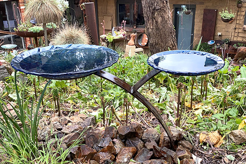Green and blue rusty bird baths with large and small bowls handmade by Tread Sculptures.