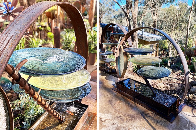 Birdbath made of reclaimed and new rolled steel, with handcrafted glass bowls and a glazed side panel that catches the light.