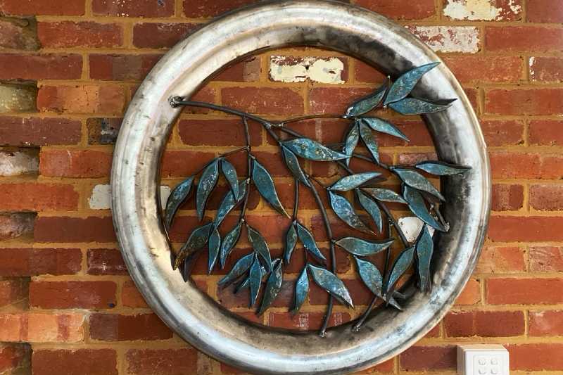 Silver Gums is set inside a reclaimed stainless steel frame with mild steel leaves plasma cut by hand to form the base for the glass.