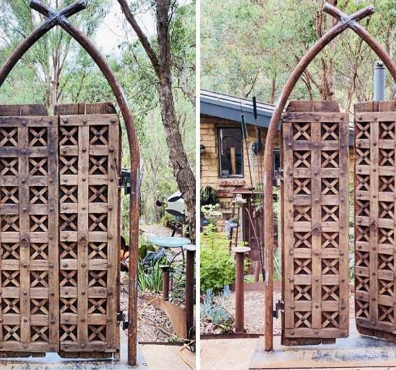 This entryway is made from teakwood and the steel button detailing on the front of the doors makes the backs look unique with the bent over spikes.