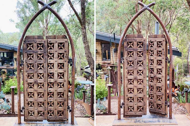 This entryway is made from teakwood and the steel button detailing on the front of the doors makes the backs look unique with the bent over spikes.