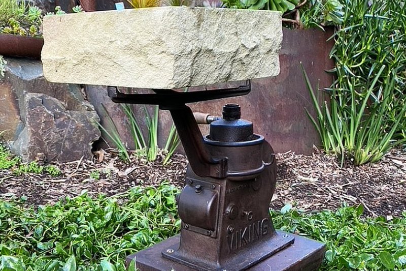 A repurposed Viking industrial pump with a unique stone base and timber handle, celebrating craftsmanship and the fusion of materials.